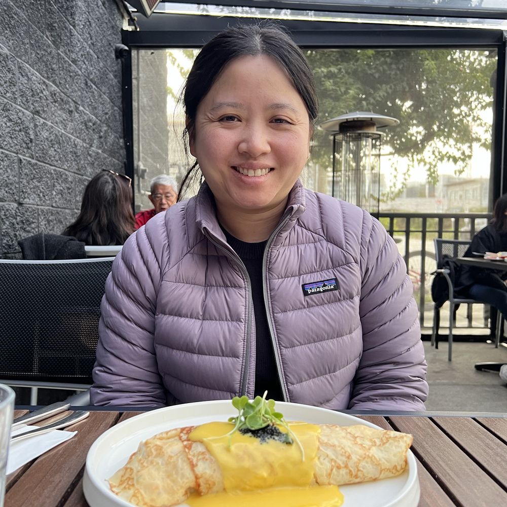 Janitta smiling at a cafe patio table